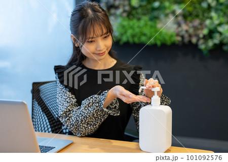 デスクで手指を消毒する女性 101092576