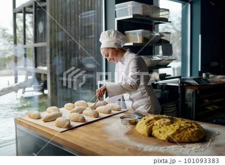 Baker engaged in making of traditional yeast buns with cheese Baker engaged in making of traditional yeast buns with cheese 101093383
