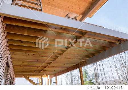 Creating layout for attached wooden deck patio of new custom built home with new flooring joists Creating layout for attached wooden deck patio of new custom built home with new flooring joists 101094154
