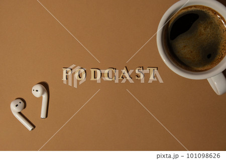 Announcement text PODCAST on beige background with white cup of coffee wireless headphones. Podcasting concept. Listening radio audio healing wellness sound 101098626