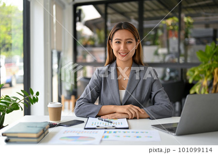 Attractive Asian businesswoman or female boss in formal business suit sits at her desk Attractive Asian businesswoman or female boss in formal business suit sits at her desk 101099114