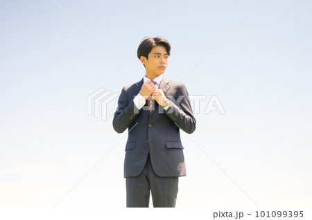 ネクタイを絞め直す若手ビジネスマン 101099395