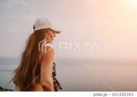 Woman travel sea. Happy tourist taking picture outdoors for memories. Woman traveler looks at the edge of the cliff on the sea bay of mountains, sharing travel adventure journey Woman travel sea. Happy tourist taking picture outdoors for memories. Woman traveler looks at the edge of the cliff on the sea bay of mountains, sharing travel adventure journey 101102363