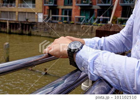 Young man in China Wharf London wearing fashion watch Young man in China Wharf London wearing fashion watch 101102510