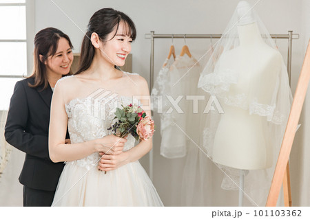 結婚式の準備でブーケとウェディングドレスの衣装合わせをするアジア人女性(試着・フィッティング) 結婚式の準備でブーケとウェディングドレスの衣装合わせをするアジア人女性(試着・フィッティング) 101103362