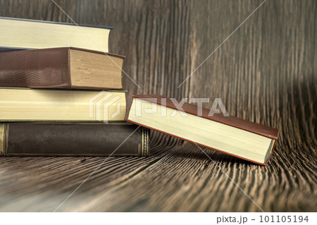 Education learning concept with opening book or textbook at home in office room, stack piles of literature text academic archive on reading desk and aisle of bookshelves in school study class room Education learning concept with opening book or textbook at home in office room, stack piles of literature text academic archive on reading desk and aisle of bookshelves in school study class room 101105194
