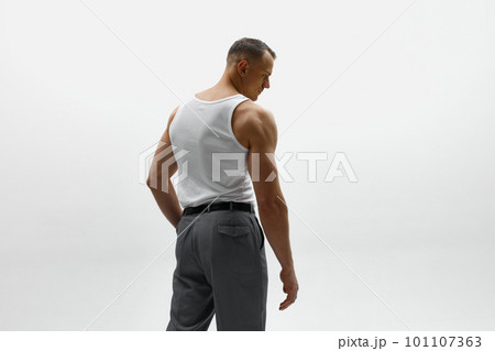 Portrait of muscular male fashion model wearing white t-shirt and posing over studio background. Masculinity Portrait of muscular male fashion model wearing white t-shirt and posing over studio background. Masculinity 101107363