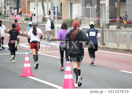 マラソン大会で懸命に走る女性ランナーたち 101107619