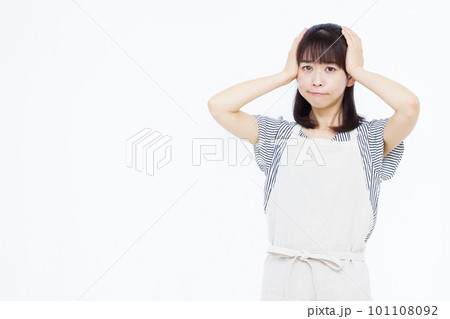 頭を抱えて悩むエプロン姿の30代主婦 頭を抱えて悩むエプロン姿の30代主婦 101108092