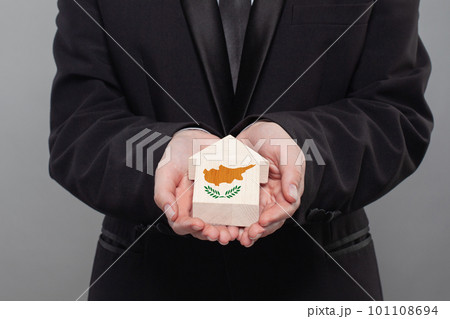 Cyprus person holding wooden house with flag of Cyprus Finance, investment, mortgage Cyprus person holding wooden house with flag of Cyprus Finance, investment, mortgage 101108694