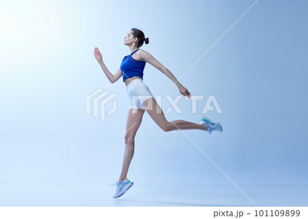 Active sportive young girl in comfortable sportswear training, doing workout exercises against light blue studio background Active sportive young girl in comfortable sportswear training, doing workout exercises against light blue studio background 101109899