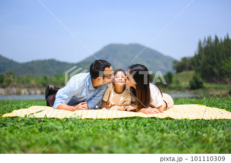 Happy family relaxing and playing outdoor together in park on weekend Happy family relaxing and playing outdoor together in park on weekend 101110309