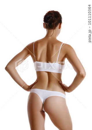 Perfect, slim, young body of a girl in white underwear posing back, isolated on white. Plastic surgery and aesthetic cosmetology concept. Close-up. Perfect, slim, young body of a girl in white underwear posing back, isolated on white. Plastic surgery and aesthetic cosmetology concept. Close-up. 101110364