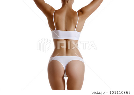Perfect, slim, young body of a girl in white underwear posing back, isolated on white. Plastic surgery and aesthetic cosmetology concept. Close-up. Perfect, slim, young body of a girl in white underwear posing back, isolated on white. Plastic surgery and aesthetic cosmetology concept. Close-up. 101110365