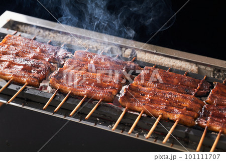 炭火で鰻の蒲焼を焼く 101111707