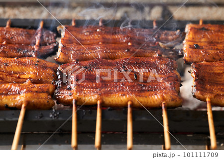 炭火で鰻の蒲焼を焼く 101111709