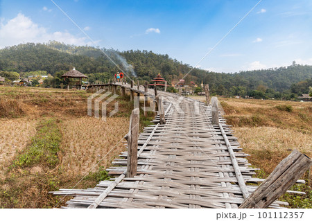 Tourist walking on the Buddha bamboo bridge or Boon Ko Ku So stretches 800 meter long split-bamboo walkway across rice fields and up to a small temple. Tourist walking on the Buddha bamboo bridge or Boon Ko Ku So stretches 800 meter long split-bamboo walkway across rice fields and up to a small temple. 101112357