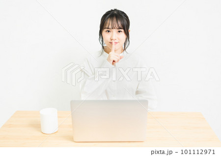 PCの前で秘密のポーズをする若い女性 101112971
