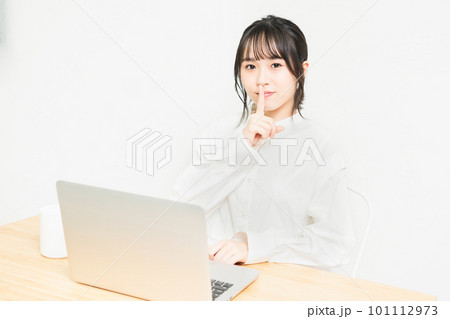 PCの前で秘密のポーズをする若い女性 101112973