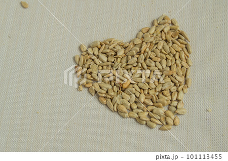 Sunflower seeds scattered on the table in the shape of a heart, the concept of a healthy diet Sunflower seeds scattered on the table in the shape of a heart, the concept of a healthy diet 101113455
