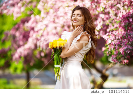 Spring Style. Beautiful Young Brunette Woman In Nice Spring Dress With A Bouquet Of Tulips. Spring Style. Beautiful Young Brunette Woman In Nice Spring Dress With A Bouquet Of Tulips. 101114513