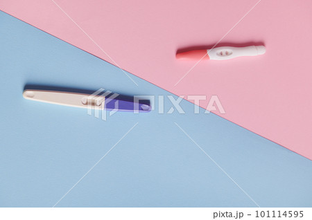 Rapid diagnosis of pregnancy. Pregnancy tests with two bars on isolated blue and pink color pastel background. Copy space. Women's health, gynecology and medicine concept. Planning maternity concept Rapid diagnosis of pregnancy. Pregnancy tests with two bars on isolated blue and pink color pastel background. Copy space. Women's health, gynecology and medicine concept. Planning maternity concept 101114595