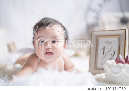 明るい自然光でハーフバースデーをお祝いする生後6か月の天使の赤ちゃん 101114729