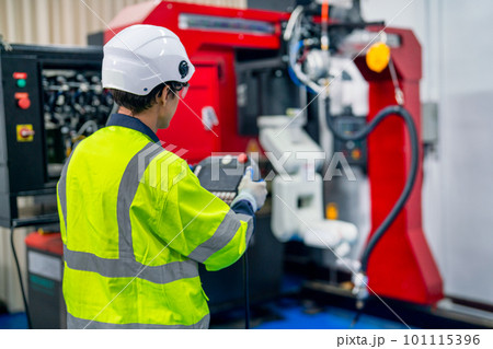 Back of professional technician or engineer use controller to work with factory robotic arm machine Back of professional technician or engineer use controller to work with factory robotic arm machine 101115396
