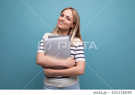 successful confident young woman student with a laptop in her hands on a blue isolated background successful confident young woman student with a laptop in her hands on a blue isolated background 101116040