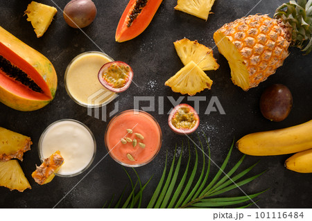Pineapple lassi or smoothie in glass on black background. Pineapple lassi or smoothie in glass on black background. 101116484