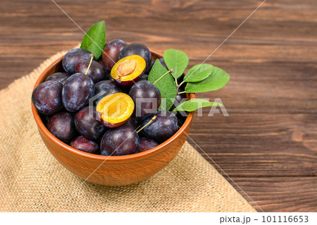 Fresh blue plums in a bowl on a wooden background. Copyspace. Fresh blue plums in a bowl on a wooden background. Copyspace. 101116653