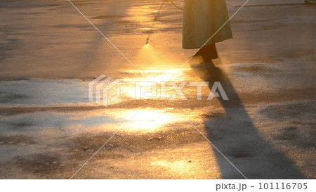 Man in airtight suit sprays disinfecting liquid a pavement on a street in the city against the backdrop of a sunset. Sanitation workers clean a crosswalk. Sanitary measures. coronavirus pandemic Man in airtight suit sprays disinfecting liquid a pavement on a street in the city against the backdrop of a sunset. Sanitation workers clean a crosswalk. Sanitary measures. coronavirus pandemic 101116705