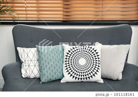 Stylish decorative pillows on grey couch indoors, closeup Stylish decorative pillows on grey couch indoors, closeup 101118161