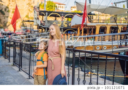 Mom and son tourists in Old town Kaleici in Antalya. Turkiye. Panoramic view of Antalya Old Town port, Taurus mountains and Mediterrranean Sea, Turkey. Traveling with kids concept Mom and son tourists in Old town Kaleici in Antalya. Turkiye. Panoramic view of Antalya Old Town port, Taurus mountains and Mediterrranean Sea, Turkey. Traveling with kids concept 101121071