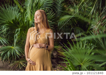 Pregnant woman walks in park at evening. Family enjoying pregnancy. The concept of Mother's Day and Women's Day 101121840