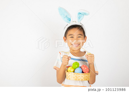 Happy Easter Day. Smile Asian little boy wearing easter bunny ears holding basket of full colorful eggs smiles broadly isolated on white background with copy space, Happy child in holiday Happy Easter Day. Smile Asian little boy wearing easter bunny ears holding basket of full colorful eggs smiles broadly isolated on white background with copy space, Happy child in holiday 101123986