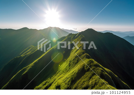 Beautiful sunrise over the green mountains in morning light with fluffy clouds on a bright blue sky. Nature freshness concept 101124955