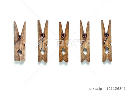 A group of shabby vintage wooden clothespins lie in a row isolated on a white background 101126841