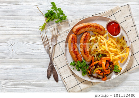 Grilled sausages, peppers, onion and french fries 101132480