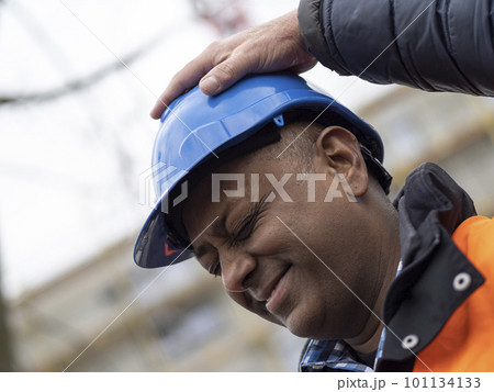 Funny profile portrait of an Indian civil engineer or factory worker closing eyes while someone out of the shot puts the hand on his face Funny profile portrait of an Indian civil engineer or factory worker closing eyes while someone out of the shot puts the hand on his face 101134133