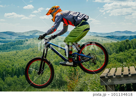 male rider on downhill bike jumping wooden drop, racing DH mountain bike, extreme sport games male rider on downhill bike jumping wooden drop, racing DH mountain bike, extreme sport games 101134618