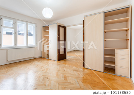 an empty room in an apartment with a wardrobe and a wooden parquet floor an empty room in an apartment with a wardrobe and a wooden parquet floor 101138680