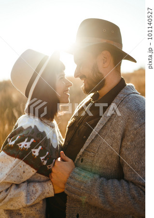 Lovely hipster couple looking at each other. Couple wearing beautiful hats and sweaters. 101140527