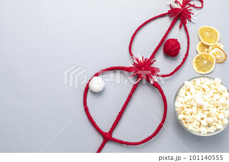 Flat lay Bulgarian Traditional Cornel Christmas Stick With Dried Fruits, Orange, Red, White Threads, Popcorn. Survakane, Survachka, Surva On Gray Background.Copy space For text,Horizontal Plane 101140555