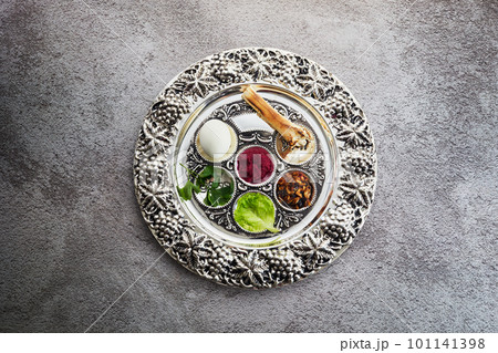 Passover Seder plate with traditional food on grunge background Passover Seder plate with traditional food on grunge background 101141398