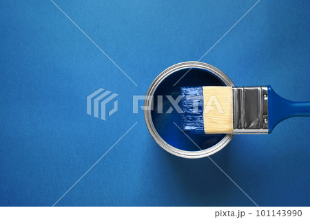 Can of paint and brush on bright background, top view with space for text. Color of the year 2020 (Classic blue) 101143990
