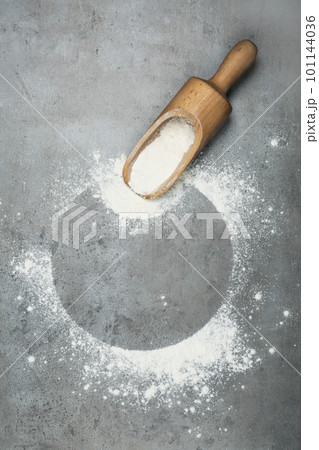 Flour and wooden scoop on light grey table, top view. Space for text 101144036