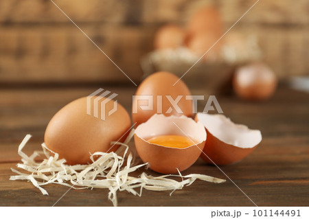 Raw brown chicken eggs and decorative straw on wooden table Raw brown chicken eggs and decorative straw on wooden table 101144491