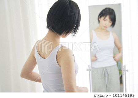 鏡の前でダイエットに悩む女性 101146193