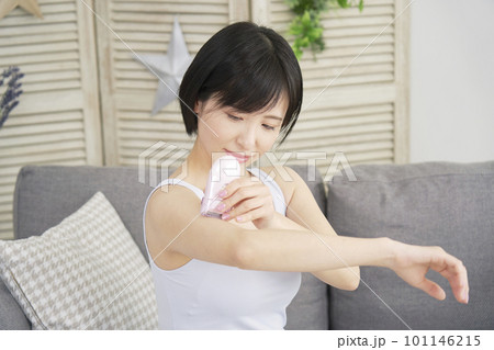 リビングで家庭用脱毛器で腕のセルフ脱毛をする女性 リビングで家庭用脱毛器で腕のセルフ脱毛をする女性 101146215